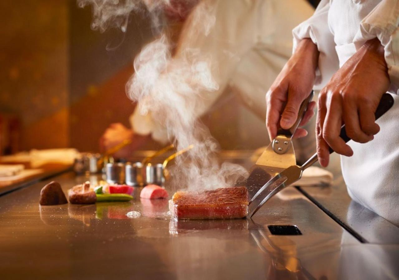 Imperial Hotel Tokyo Esterno foto A chef seasoning a steak